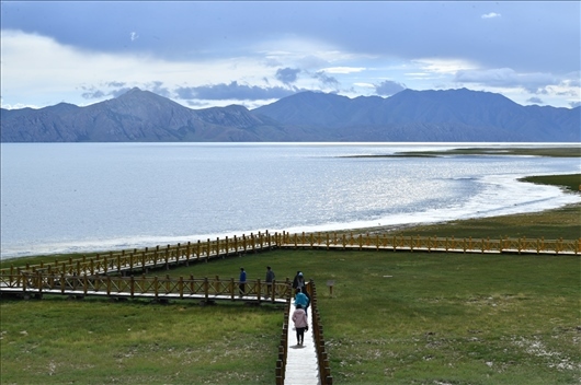 △ 游客行走在青?，敹嗫h冬格措納湖畔的木棧道上。