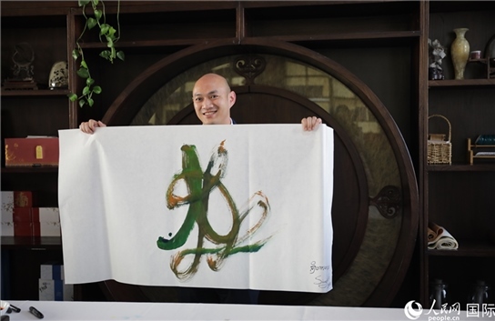 老撾駐華大使館三秘明君參加《五百筆·瀾湄合作》集體藝術創(chuàng)作。人民網王婧攝。