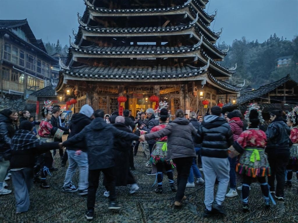 法國(guó)青年與當(dāng)?shù)卮迕駹渴痔?。新華社記者 羅羽 攝