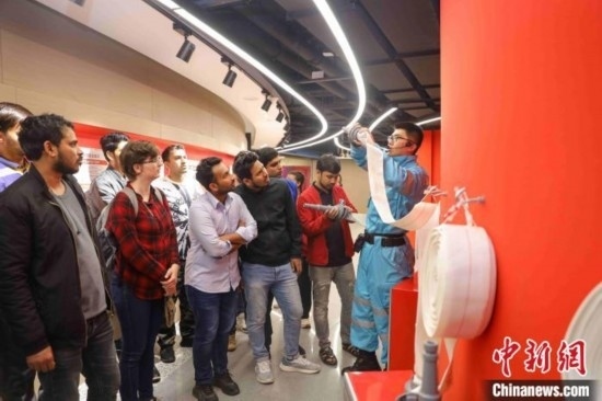 5月9日，工作人員指導(dǎo)留學(xué)生正確使用消防水帶。張鷹 攝