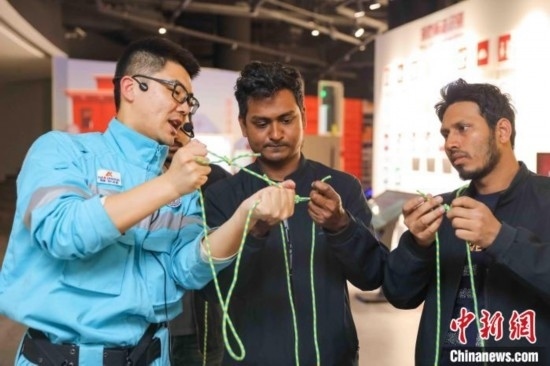 5月9日，工作人員指導(dǎo)留學(xué)生學(xué)習(xí)打繩結(jié)。張鷹 攝