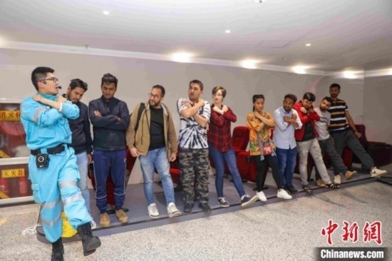 5月9日，工作人員指導(dǎo)留學(xué)生練習(xí)逃生技巧。張鷹 攝