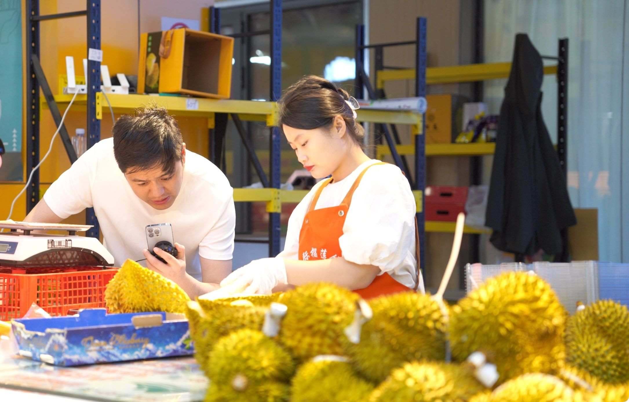 榴蓮商家正在通過(guò)手機(jī)直播銷(xiāo)售榴蓮。人民網(wǎng)記者申佳平 攝