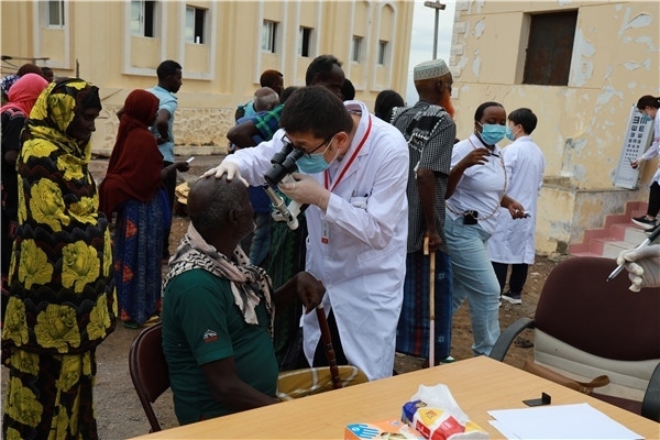 在義診現(xiàn)場，中國醫(yī)生與當?shù)鼐用窈嫌傲裟睿继猁}業(yè)投資公司供圖