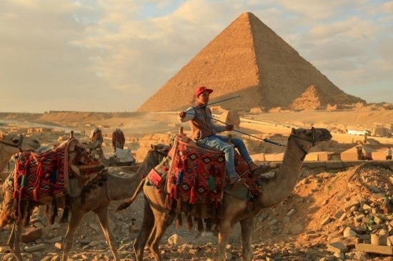 1月24日，商販騎駱駝離開埃及吉薩金字塔景區(qū)。新華社記者 隋先凱 攝