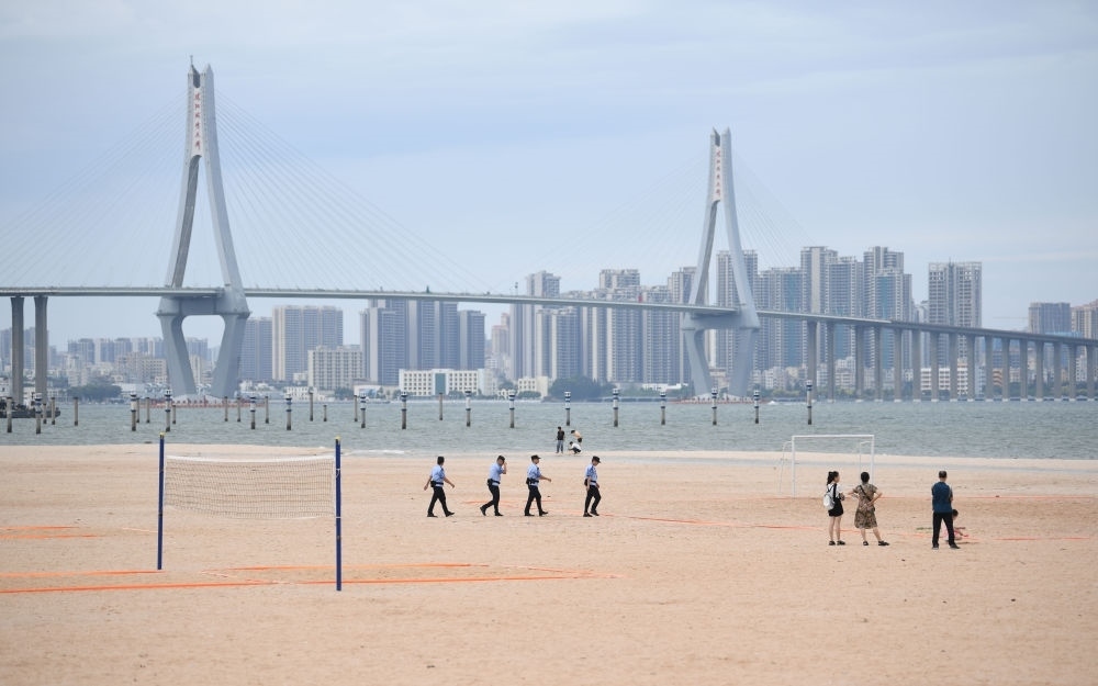 2023年7月17日，廣東湛江五環(huán)廣場的沙灘上，公安民警在執(zhí)勤巡邏。新華社記者 鄧華 攝