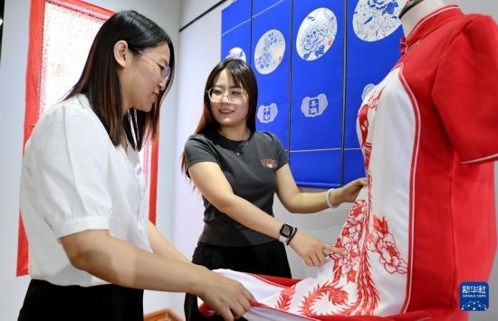 5月31日，在衡水市阜城縣一家剪紙工作室，游客在觀賞帶有剪紙?jiān)氐钠炫邸? width=