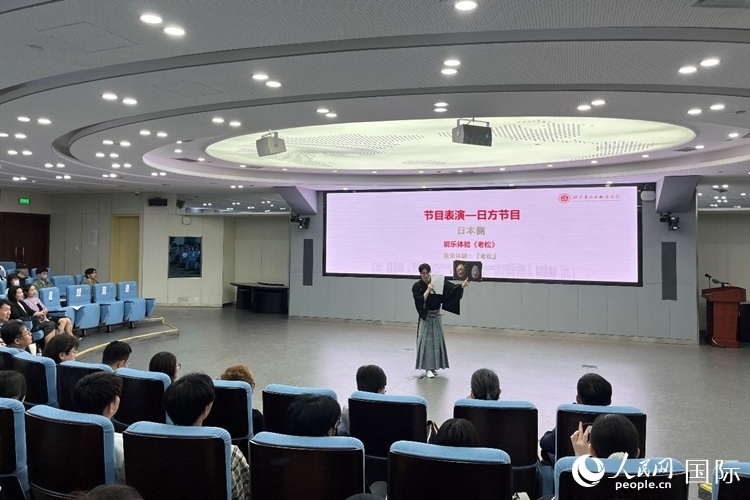 日本大學(xué)生介紹能樂知識(shí)。人民網(wǎng)記者 陳思攝