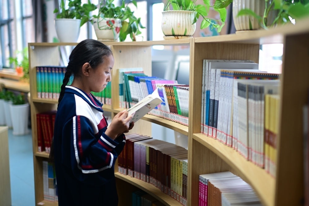 6月18日，果洛西寧民族中學(xué)學(xué)生尼東拉毛在圖書室看書。