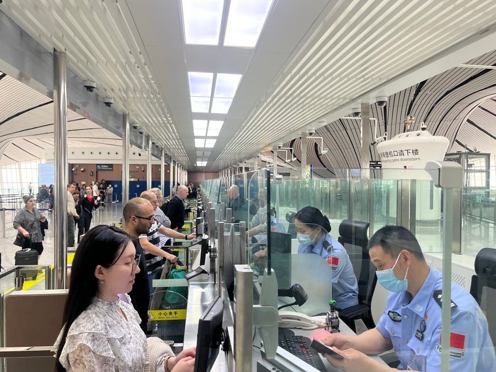 7月5日，北京大興國際機(jī)場邊檢站民警正在辦理邊檢查驗(yàn)手續(xù)。（北京大興國際機(jī)場邊檢站供圖）