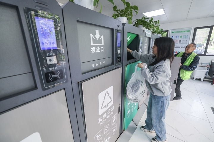 2024年4月10日，在浙江省湖州市吳興區(qū)飛英街道新華府小區(qū)內(nèi)，居民在垃圾分類智能系統(tǒng)的指導(dǎo)下進(jìn)行垃圾分類投放，居民的投放情況將實(shí)時(shí)匯總到智慧服務(wù)平臺(tái)，會(huì)有相應(yīng)的積分獎(jiǎng)勵(lì)。新華社記者 徐昱 攝