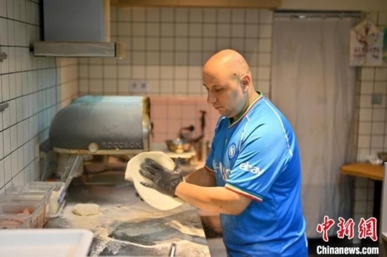 近日，韋榮耀在自家披薩小店內(nèi)忙活。俞靖 攝