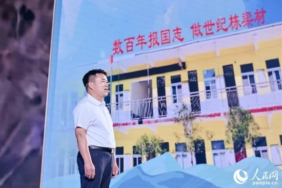 張玉滾分享用一根扁擔(dān)送孩子們走出大山的故事。人民網(wǎng)攝