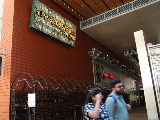 2023年5月29日，人們經(jīng)過(guò)美國(guó)紐約曼哈頓的“國(guó)債鐘”。“國(guó)債鐘”是一個(gè)大型計(jì)數(shù)器，它實(shí)時(shí)更新美國(guó)的公共債務(wù)總額，并顯示出每個(gè)美國(guó)家庭所要負(fù)擔(dān)的數(shù)額。 新華社記者劉亞南攝