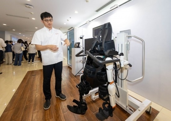 2024年5月24日，在位于上海市嘉定區(qū)的上海交通大學醫(yī)學院附屬瑞金醫(yī)院腫瘤質(zhì)子中心，工作人員介紹由瑞金醫(yī)院醫(yī)生和醫(yī)療公司共同研發(fā)的用于恢復患者下肢的醫(yī)療機器人。新華社記者 王翔 攝