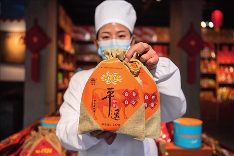 在位于山西省晉中市平遙縣的平遙古城南大街的一家平遙牛肉店內(nèi)，工作人員展示一款牛肉產(chǎn)品（資料照片）楊晨光攝 / 本刊