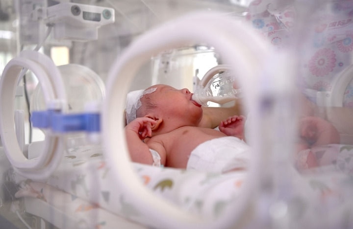 2024年6月1日，在西安國(guó)際醫(yī)學(xué)中心醫(yī)院新生兒科病房，護(hù)士為新生兒喂奶。 新華社記者 劉瀟 攝