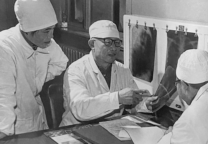 1980年1月16日，中日友好醫(yī)院首任院長(zhǎng)辛育齡（中）在內(nèi)蒙古結(jié)核病院與胸外科醫(yī)師討論病例（翻拍照片）。 新華社發(fā)