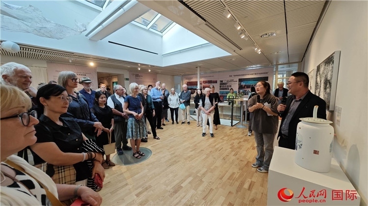 參展人、景德鎮(zhèn)陶瓷大學(xué)美術(shù)學(xué)院副院長邵長宗（右一）向來賓介紹參展作品。人民網(wǎng)記者 殷淼攝