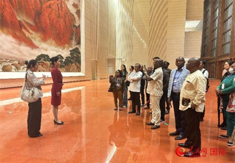 代表團(tuán)在入口處聽取講解。人民網(wǎng) 曹欣悅攝