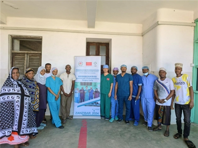 隊長蔣國慶（右七）和手術醫(yī)生、部分患者合影。中國援桑醫(yī)療隊供圖