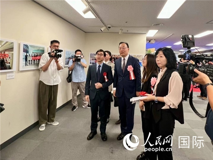 中國國際航空日韓地區(qū)支社支社長馮力為中國駐日本大使館臨時代辦施泳等嘉賓介紹展出圖片。人民網(wǎng) 許可攝