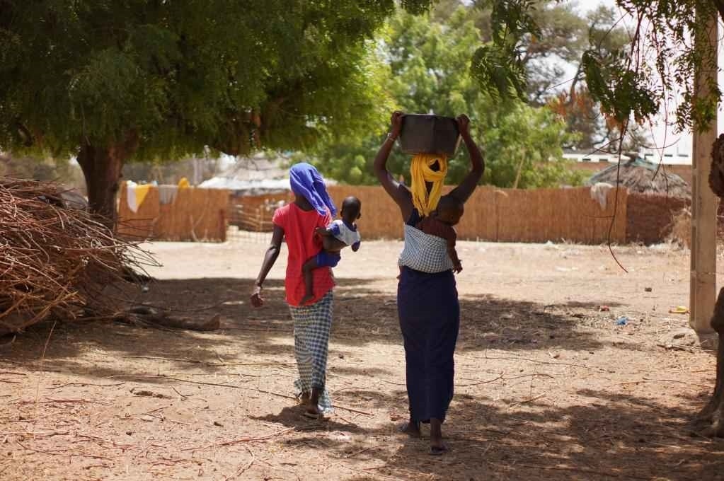 2023年3月20日，在塞內(nèi)加爾久爾貝勒區(qū)的泰內(nèi)富勒村，村民將取到的水運回家。新華社記者 王子正 攝