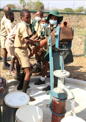 △2021年11月，在津巴布韋南馬塔貝萊蘭省省會關(guān)達的塞農(nóng)多小學(xué)，學(xué)生從中國援建水井里打水。