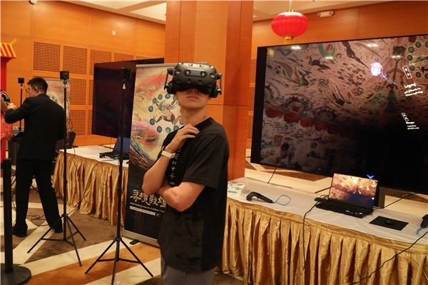 1、在本次活動的展覽現(xiàn)場，敦煌研究院與騰訊展示了“數(shù)字藏經(jīng)洞”和“尋境敦煌”等創(chuàng)新互動產品。圖為當?shù)孛癖娡ㄟ^VR虛擬游覽洞窟。 人民網(wǎng)記者 李志偉攝
