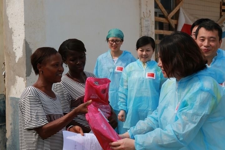 2015年4月4日，在位于塞拉利昂首都弗里敦市郊的中塞友好醫(yī)院埃博拉診療中心，中國第四批援塞醫(yī)療隊副隊長邵蔚（右前）向被治愈的埃博拉出血熱患者贈送禮物。新華社發(fā)（祖榮強 攝）