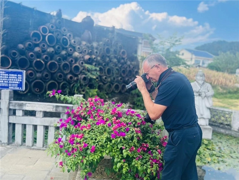 遠(yuǎn)處黔北民居錯(cuò)落有致，近處一只黑色的蝴蝶穿梭于粉紫色三角梅花叢間隙，與俄羅斯“大歐亞”總編輯弗拉基米爾·別列日內(nèi)赫的鏡頭玩起了捉迷藏，“你追我逃，不亦樂(lè)乎”。（張亞欣攝）