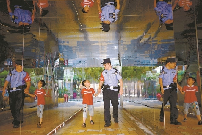 ?7月16日，重慶市公安局江北區(qū)分局一名民警在巡邏途中遇到一個獨自玩耍的小男孩，民警將其送回家。王洪平攝