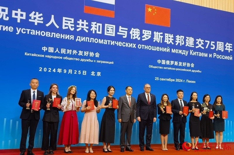 楊萬明會長和莫爾古洛夫大使為10位中俄青年友好微視頻創(chuàng)意大賽獲獎代表頒獎。人民網記者 李明琪攝