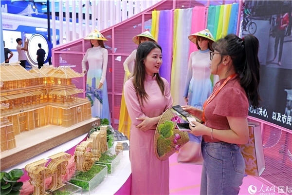 參觀者在東博會(huì)越南展區(qū)同工作人員咨詢交談。人民網(wǎng)記者 趙益普攝