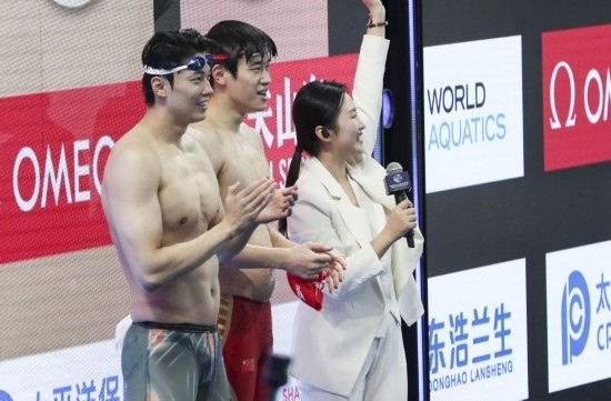  10月18日，汪順（左）和潘展樂在男子100米混合泳決賽后。新華社記者 方喆 攝