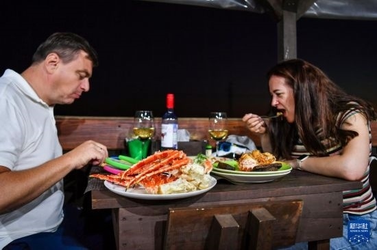 9月2日，食客們在俄羅斯符拉迪沃斯托克的一家餐館品嘗帝王蟹。新華社記者 曹陽 攝