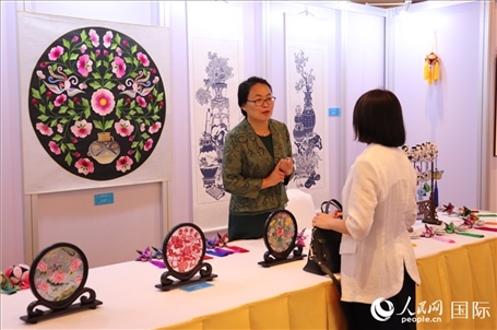 青海非遺文化傳承人向嘉賓介紹展品。人民網(wǎng)實(shí)習(xí)生姚欣可攝