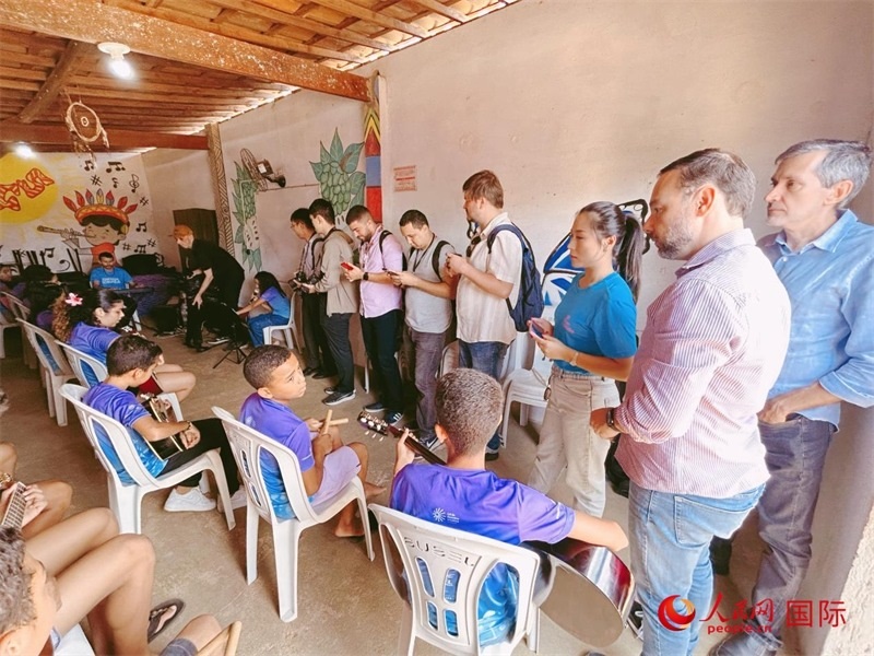  受益于中國企業(yè)的“青少年成長”項目，700多名當?shù)厍嗌倌甑囊魳泛妥闱驂粝氩迳狭顺岚?。圖為聯(lián)合采訪團正在采訪參加音樂培訓的孩子們。 人民網(wǎng)記者 陳一鳴攝