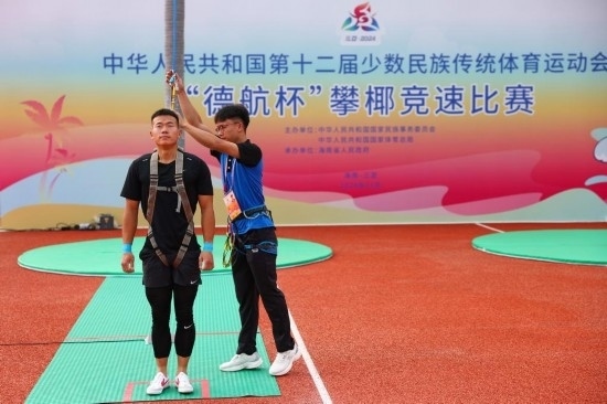 11月23日，工作人員為上海隊(duì)選手付樂樂（左）系安全繩。新華社記者 楊植森 攝