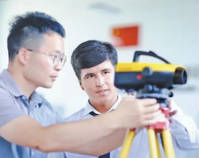 在塔吉克斯坦首都杜尚別的魯班工坊，來自天津城市建設(shè)管理職業(yè)技術(shù)學(xué)院的老師（左）為當(dāng)?shù)貙W(xué)生提供指導(dǎo)。新華社記者 鄭開君 攝