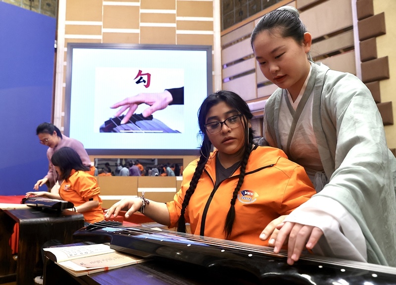 2024年3月20日，美國華盛頓州中學(xué)生代表團(tuán)北京大學(xué)交流活動在北京大學(xué)英杰交流中心舉行。圖為來自華盛頓州的中學(xué)生體驗(yàn)古琴。