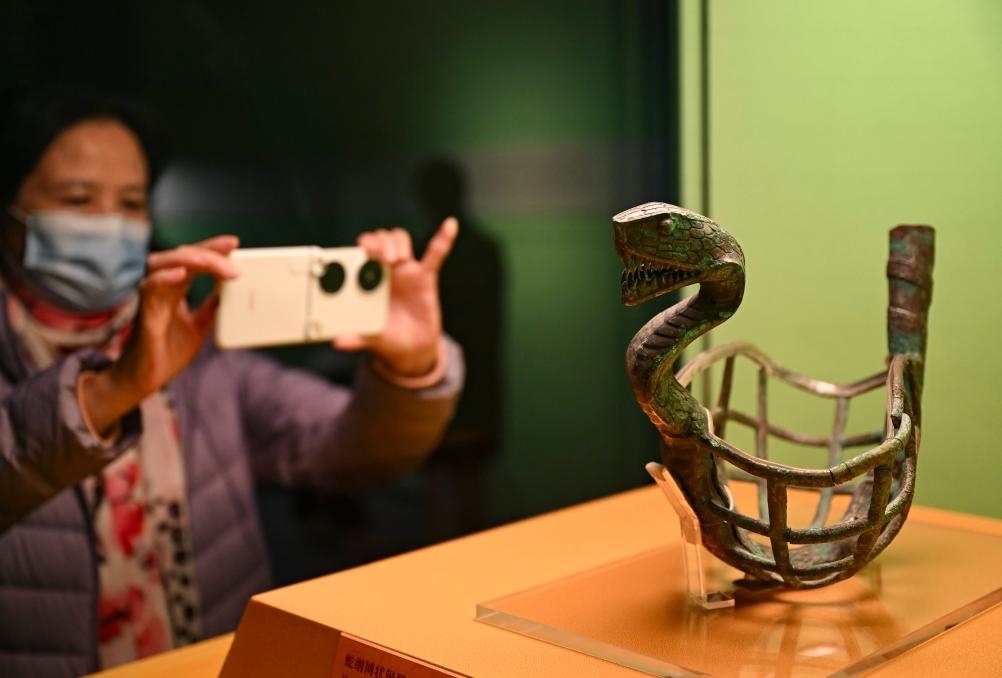 1月14日，觀眾在上海博物館蛇年迎春展拍攝展品蛇綱網(wǎng)狀銅器。新華社發(fā)（陳浩明攝）