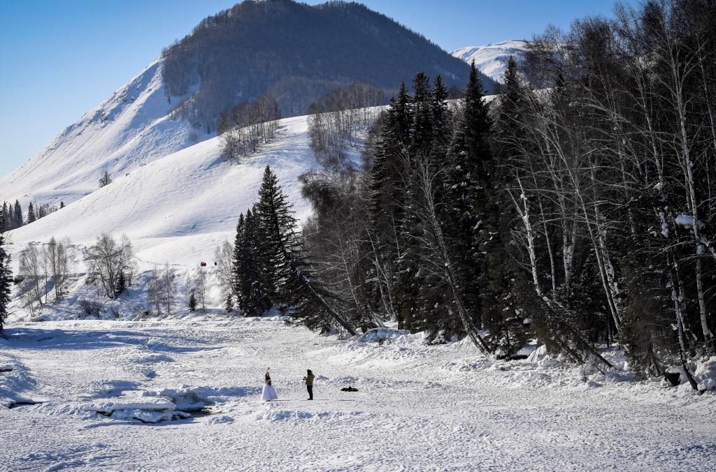2024年2月5日，兩名游客在新疆阿勒泰地區(qū)布爾津縣禾木村拍照。新華社記者 馬鍇 攝