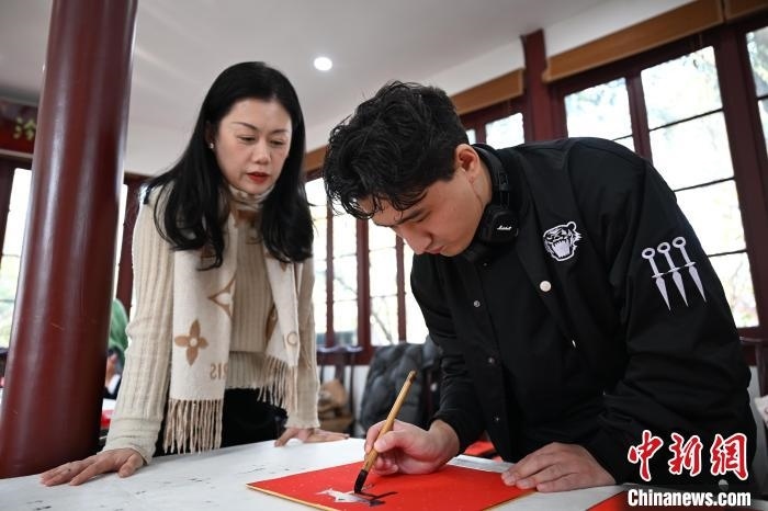 1月20日，外籍留學生在西泠印社社員李硯指導下寫福。當日，來自巴西、馬來西亞、加納、哈薩克斯坦的外籍留學生在浙江杭州西泠印社體驗福貼、春聯(lián)和篆刻，感受古老的中國傳統(tǒng)文化。中新社記者 王剛 攝