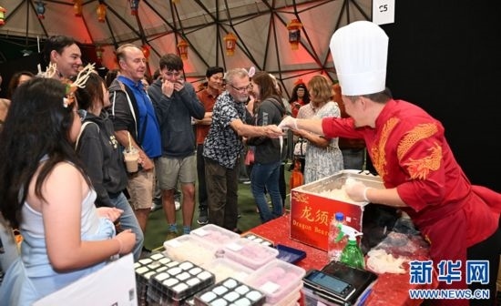 圖為游客在燈節(jié)現(xiàn)場購買小吃。（圖片由奧克蘭中國文化中心提供）