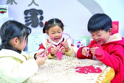 圖為孩子們?cè)诶蠋熤笇?dǎo)下制作蛇年主題剪紙。 新華社記者 徐昱攝