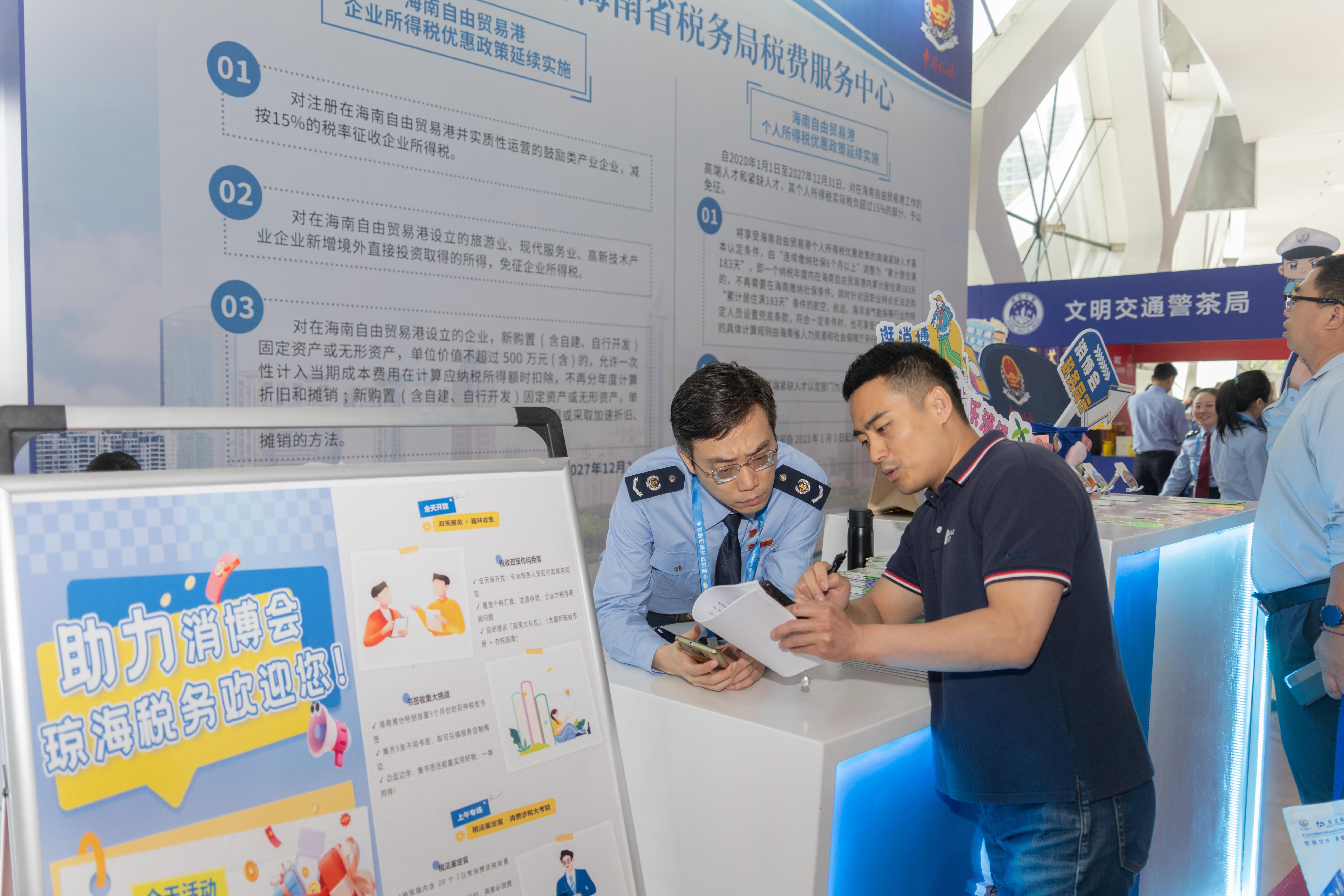 稅務服務臺工作人員向記者介紹服務參展外商的具體舉措。人民網(wǎng)記者 許崢攝