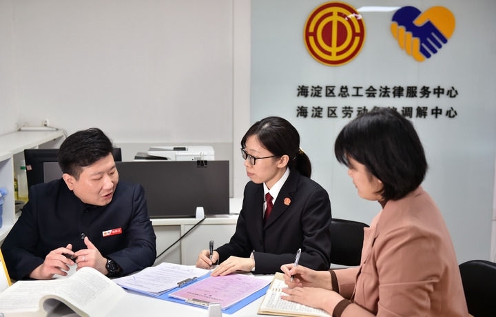 2025年3月6日，在北京市海淀區(qū)總工會勞動爭議調解中心，海淀區(qū)人民法院法官王琰（中）與該中心工作人員就糾紛化解情況進行溝通。新華社記者 趙婷婷 攝
