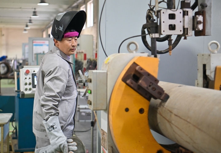 在中石化第四建設有限公司工匠學院，全國人大代表、中石化第四建設有限公司工匠學院焊接教練張振連操作自動焊機（2025年2月21日攝）。新華社記者 孫凡越 攝