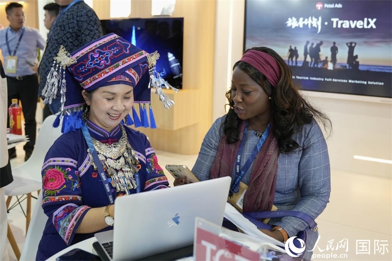 來自廣西的旅游業(yè)者同客戶交流。人民網(wǎng)塔里克·易卜拉欣攝
